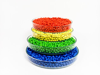Blue, green, yellow and red masterbatch plastic granules, colorful polymer pigment granules isolated on white background, for product catalog design of plastic manufacturing industry company profile