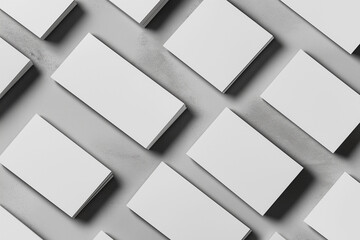Closeup of empty white rectangle business card mockups lying diagonally on neutral grey concrete background. Flat lay, top view. Open composition. Blank Template for Corporate Identity