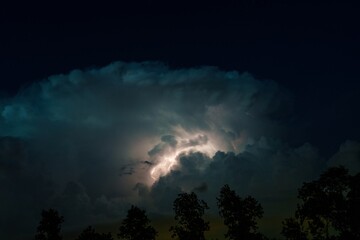 A stunning natural phenomenon in the Netherlands. The night sky is lit by a bolt of lightning from...