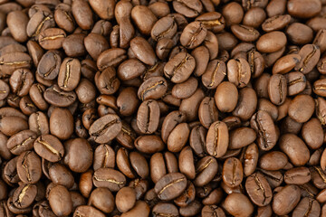 Close-up of roasted arabica coffee beans.Heap of coffee beans stacked  prepare making menu in the cafe by machine ready to be brewed into a delicious cup.Textured background.