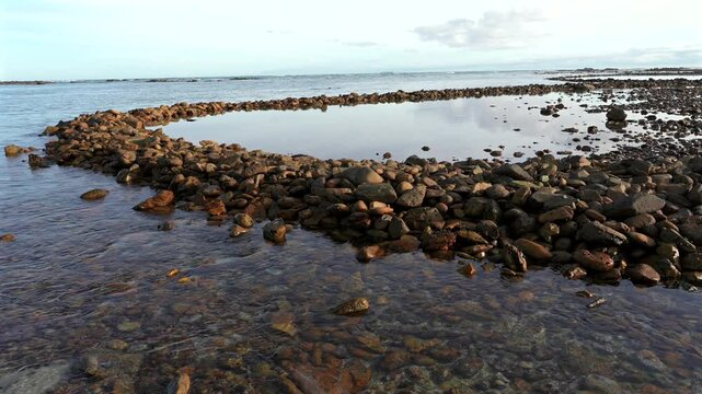 Ancient Rasperpunt fish traps along the L'Agulhas shoreline in the  Agulhas National Park. These tidal fish traps were probably built by pre-colonial Late Stone Age people. Western Cape. South Africa.