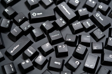 Scattered white on black mechanical keyboard keycaps on a matte black surface, control button focus. Captured from a top down perspective in a flat lay style.