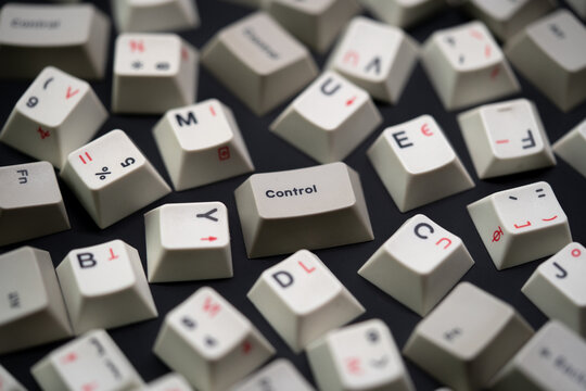 Close up scattered white keycaps with control keycap focus. Black on white mechanical keyboard keycaps on a matte black surface, captured from a top view perspective in a flat lay style. - Powered by Adobe