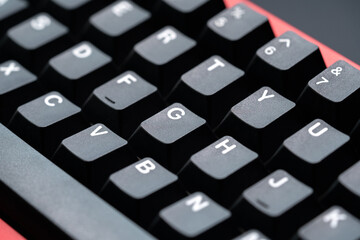 Extreme close up of black mechanical keyboard keycaps with white lettering, captured from a top-side angle for a detailed and modern aesthetic.