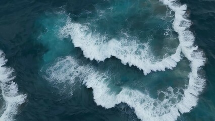 the ocean is blue and green with white waves crashing on rocks and shore rocks at the end