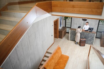 Businesswoman with luggage in modern hotel lobby