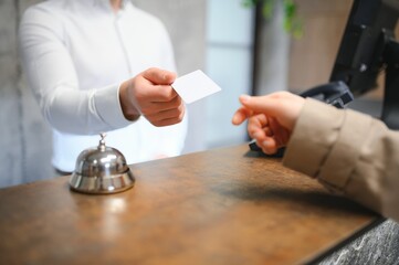 Close up of hand guest takes room key at check-in desk of the hotel. Hotel concept