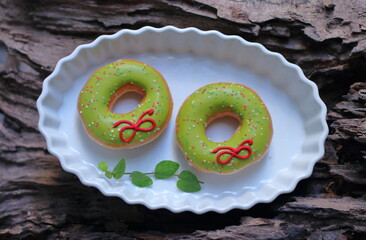 Donuts in a white plate on a wooden background