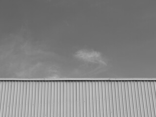 Black and white of industrial factory building with aluminum metal texture on the exterior wall, modern architecture of corrugated steel facade. Copyspace, design.