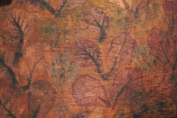 Close up of an eco print patterned fabric or clothes using leaf with brown color.