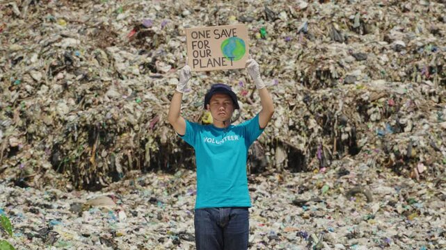 Young man holding campaign sign as a volunteer or protest. The placard has message "SAVE OUR PLANET" for activists. Concept of protester, campaigners, volunteerism, global warming potential