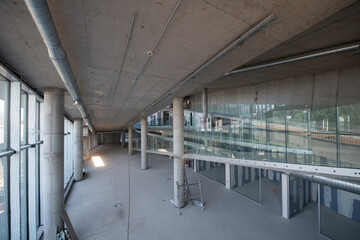 A captivating view of a modern business building under construction, showcasing its raw industrial interior with exposed steel beams and concrete walls bathed in the warm, golden hues of a sunset