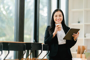 Fototapeta premium Smiling businesswoman holding phone in modern office