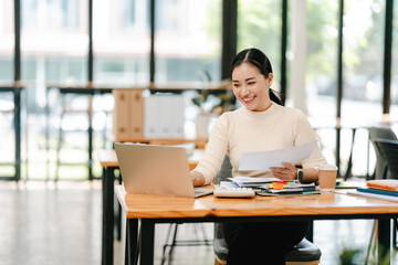 Young Asian woman doing financial accounting and taxes for a company Organizing account analysis...