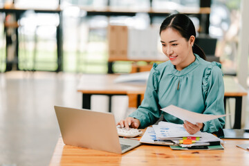 Young Asian woman doing financial accounting and taxes for a company Organizing account analysis...