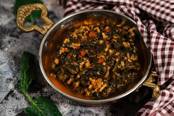 stewed spinach with rice and tomato sauce in traditional turkish brass pan