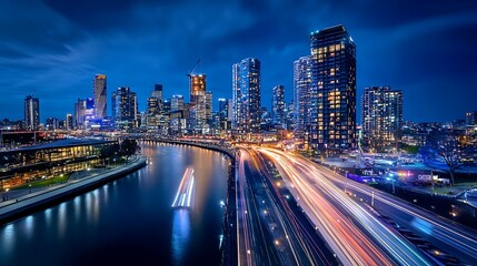 Naklejka premium Melbourne City Skyline at Night with Light Trails. Concept of urban life, modern city, and vibrant energy.
