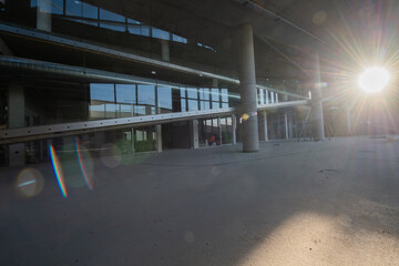 A captivating view of a modern business building under construction, showcasing its raw industrial interior with exposed steel beams and concrete walls bathed in the warm, golden hues of a sunset