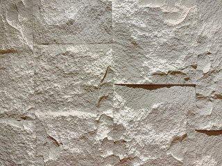 White beige rough flagstone or limestone slab random cut on a floor and wall. Seamless 3D weathered and rough natural beige stone background texture.