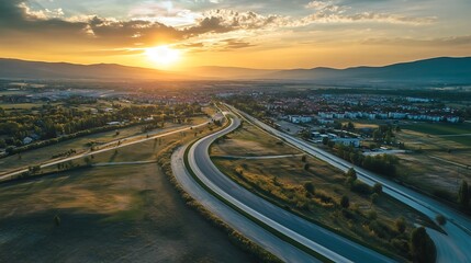 Fototapeta premium Highway at Sunset Over a Town. Scenic Road Trip, Transportation, and Travel Concept.