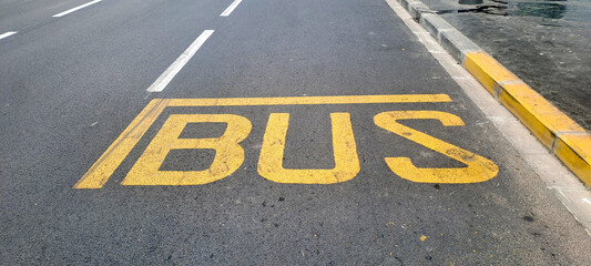 Bus stop sign painted on asphalt road surface