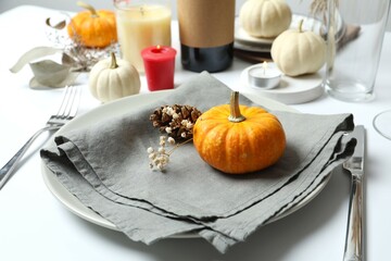 Rustic holiday table setup with plates, cutlery and autumn decorations