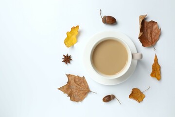 Cup of coffee with autumn leaves on a white background