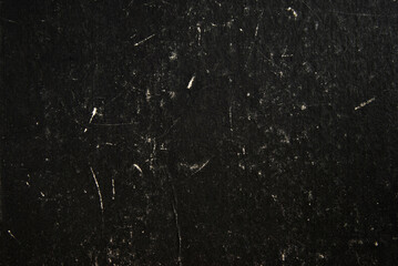 Black grunge cardboard background with scratches and smudges