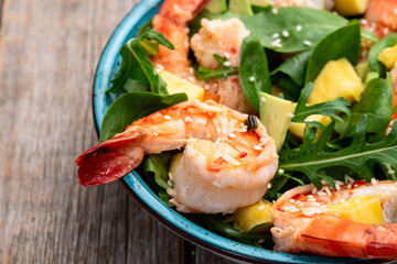 Salad with tiger shrimps , avocado and mango . Top view