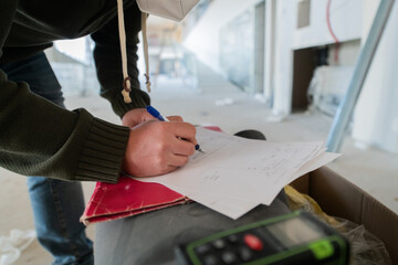 A close-up of an engineer's hand meticulously sketching an architectural project, capturing the...