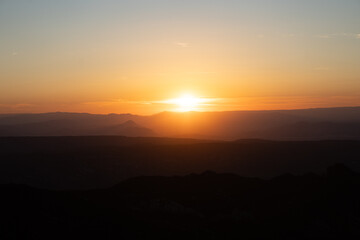 Atardecer entre las montañas con tonos naranjas