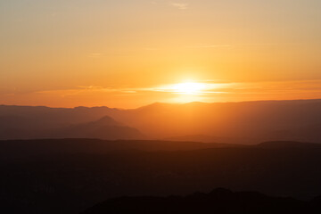 Atardecer entre las montañas con tonos naranjas