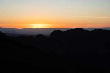 Atardecer entre las montañas con tonos naranjas