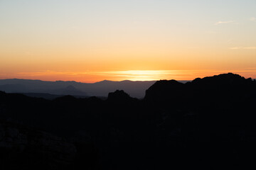 Atardecer entre las montañas con tonos naranjas