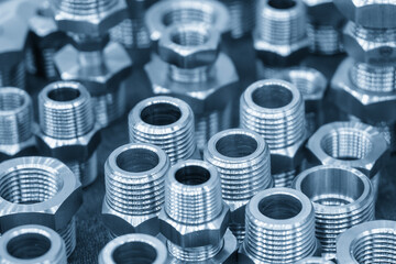 The pile of steel water pipe connector parts in the light blue scene.