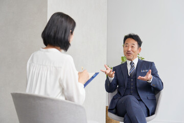 ビジネスマンにインタビューする女性記者