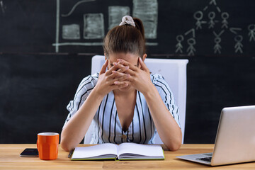 Young woman is worried and nervous at workplace.