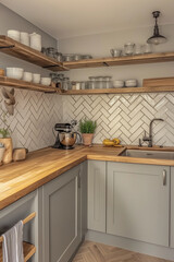  A minimal Scandinavian kitchen with cabinets and a warm wooden countertop, complemented by natural wood shelves