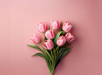 A delicate bouquet of light pink tulips arranged on a soft pink background.  The image evokes feelings of spring and romance.