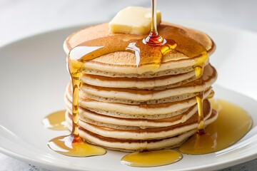 a stack of plain mini pancakes, drizzled with honey