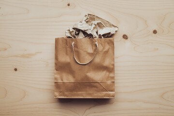 An isolated shot of a brown paper bag on a light wooden background