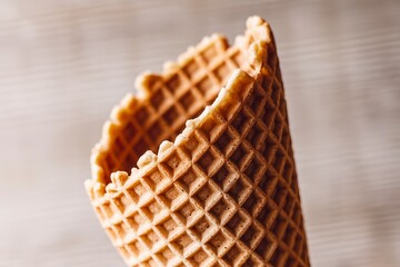 A photo of a textured waffle cone on a light wooden background