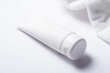 White plastic tube for cosmetic with terry towel, minimalistic concept
