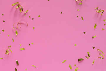 close up top view on rolling and confetti gold color on pink pastel background with copyspace for design as valentine card or mother day or wedding invitation concept