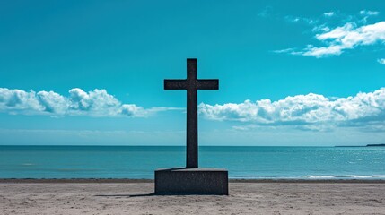 A solitary cross stands on Omaha Beach as a memorial, its silhouette stark against the vibrant blues of the sea and sky.