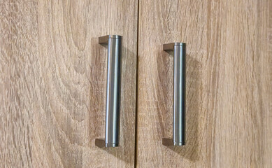 Wooden cabinet doors with sleek metal handles, showcasing modern design and craftsmanship.