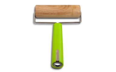 Top view of a mini dough roller with a vibrant green plastic grip, ideal for evenly rolling dough for baking, pizza, or pastries, designed for comfort and efficiency in the kitchen.