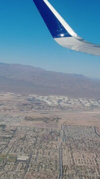 Aircraft close up wing view flying over las vegas city showing nellis air force base us air force in the distance
