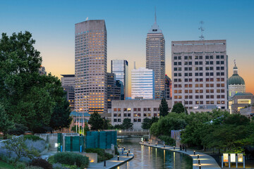 Serene and vibrant view of Indianapolis Canal Walk and skyline featuring tall office buildings, iconic Salesforce Tower, and the Indiana State Capitol dome