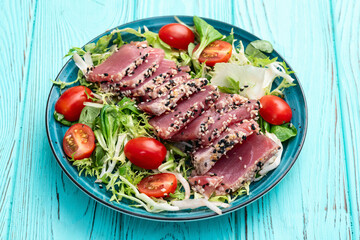 Salad with raw tuna , sesame and cherry tomatoes photography . Top view